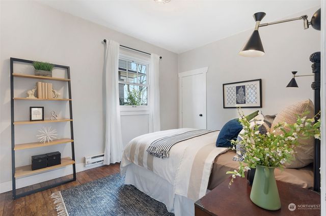 a bedroom with a bed potted plant and the dresser