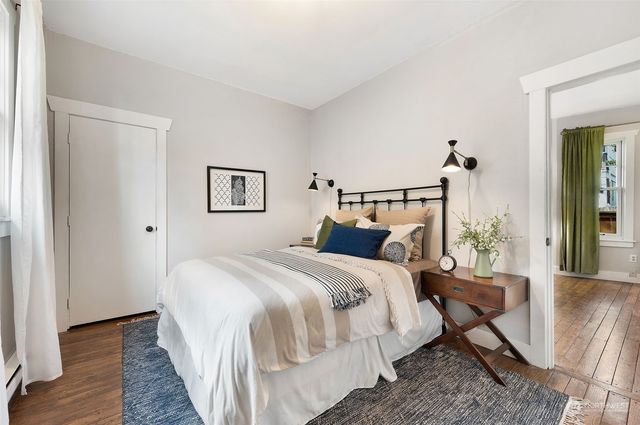 a bedroom with bed and wooden floor