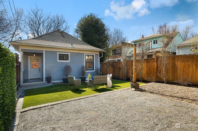 a view of a house with backyard and sitting area