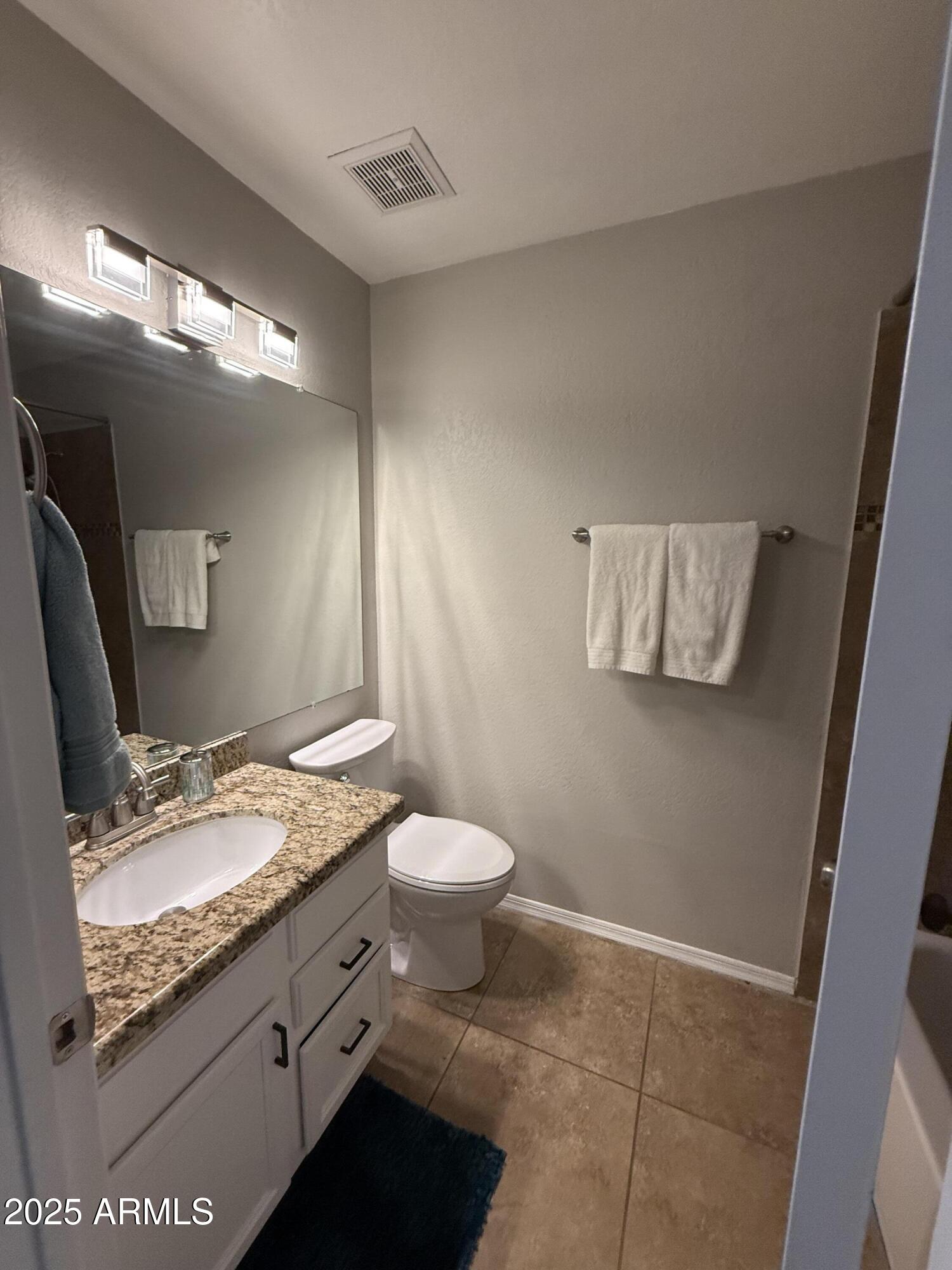 7977 West Wacker Road, Unit 249 Peoria, AZ 85381 - Photo 12 of 17 a bathroom with a granite countertop sink toilet and mirror