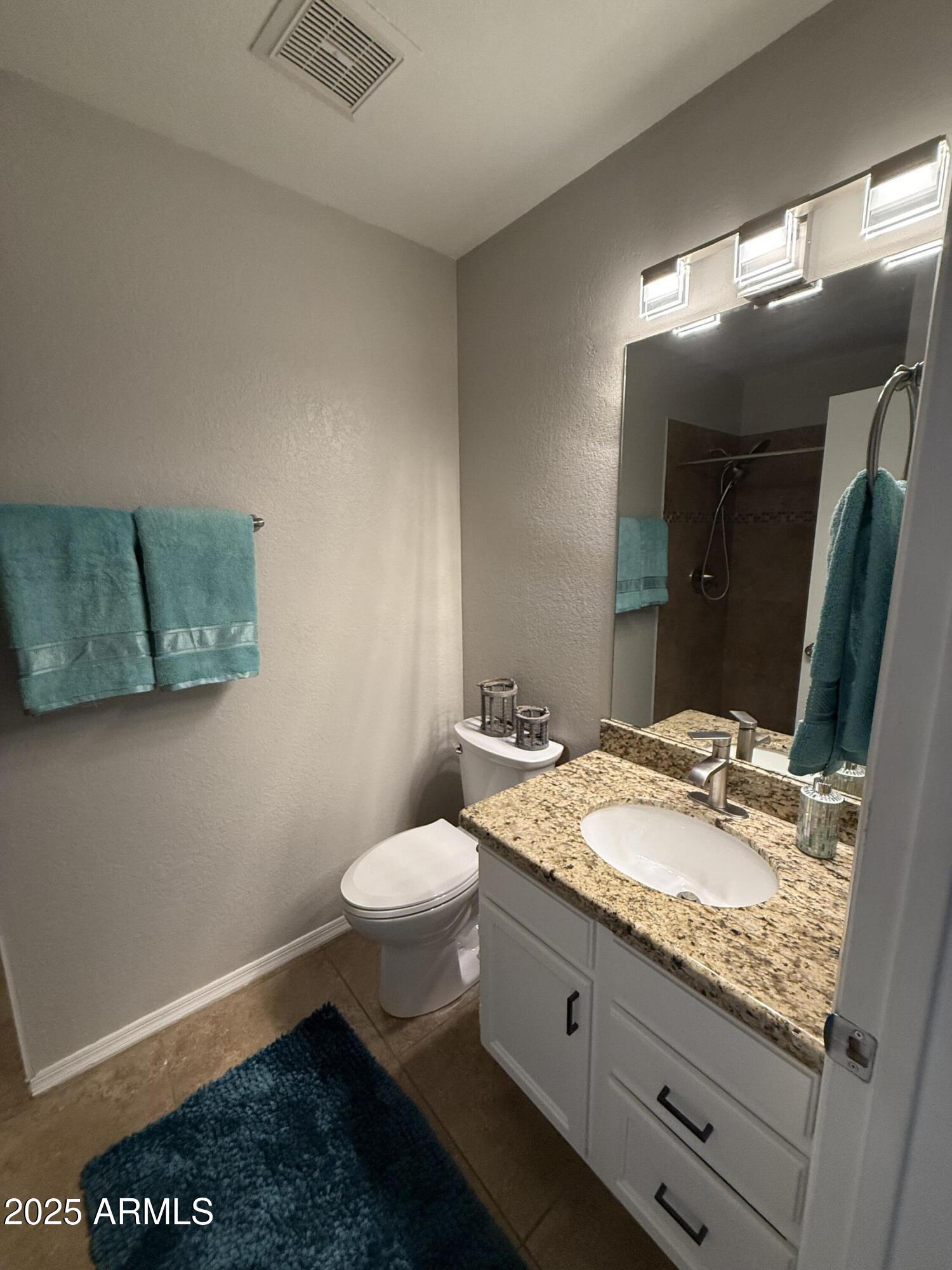 7977 West Wacker Road, Unit 249 Peoria, AZ 85381 - Photo 16 of 17 a bathroom with a granite countertop sink mirror vanity and toilet