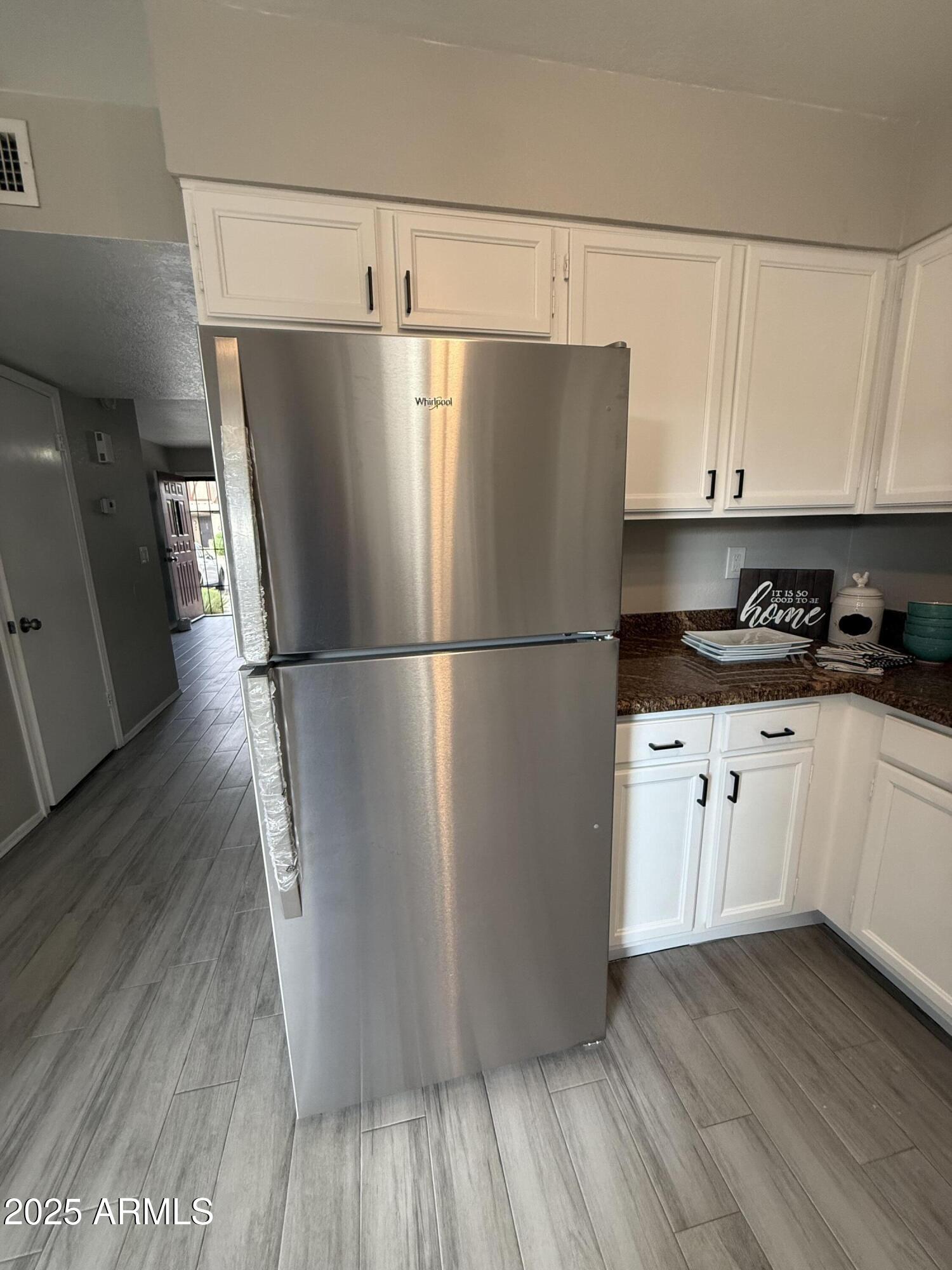 7977 West Wacker Road, Unit 249 Peoria, AZ 85381 - Photo 2 of 17 a kitchen with cabinets and wooden floor