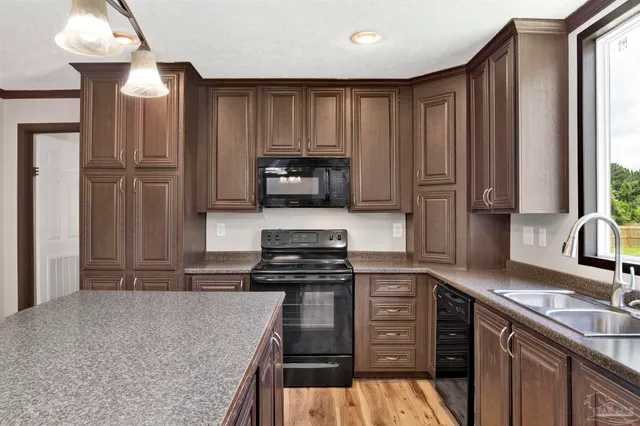 a kitchen with kitchen island granite countertop a stove sink and cabinets