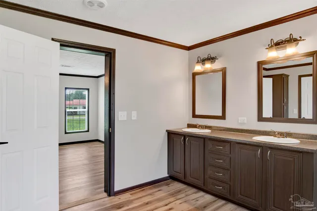 a en suite bathroom with a granite countertop sink and a mirror