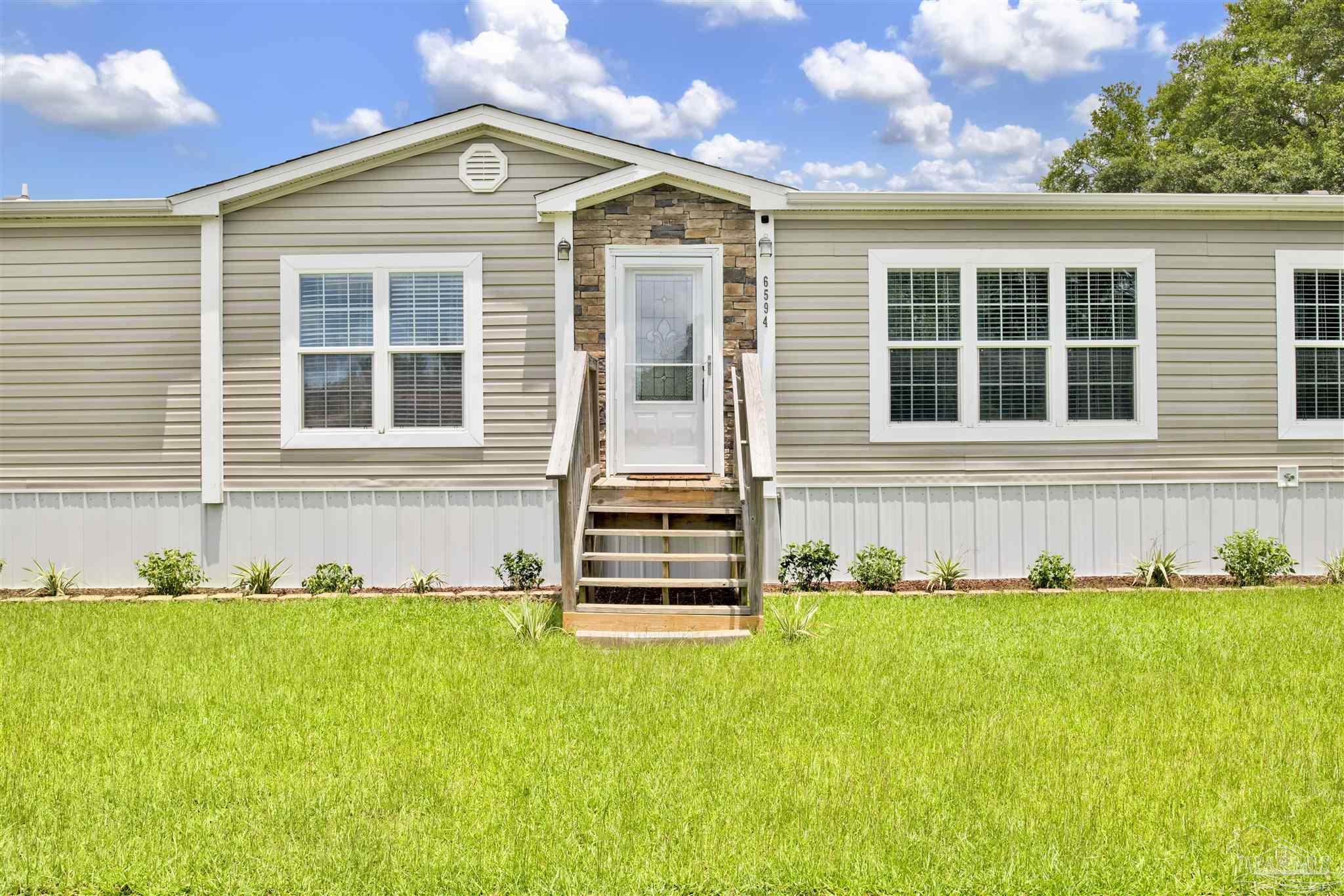 6594 Will Jones Road Jay, FL 32565 - Photo 2 of 39 a front view of a house with a yard