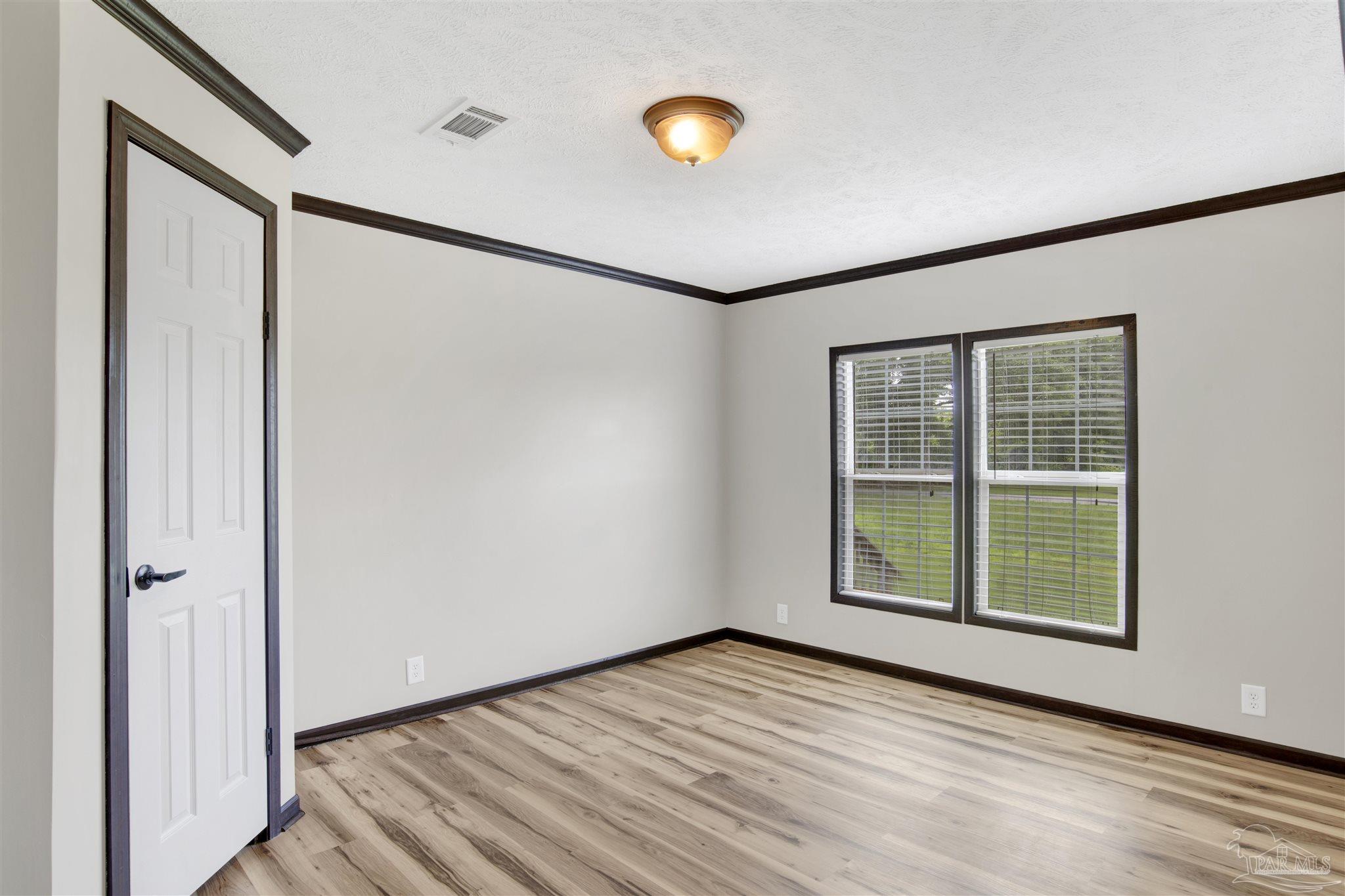 6594 Will Jones Road Jay, FL 32565 - Photo 23 of 39 a view of an empty room with wooden floor and a window