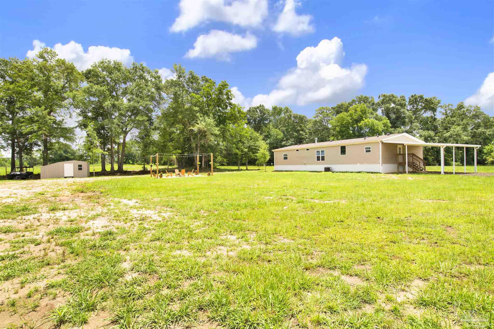 6594 Will Jones Road Jay, FL 32565 - Photo 34 of 39 a view of a swimming pool with an outdoor space and seating area
