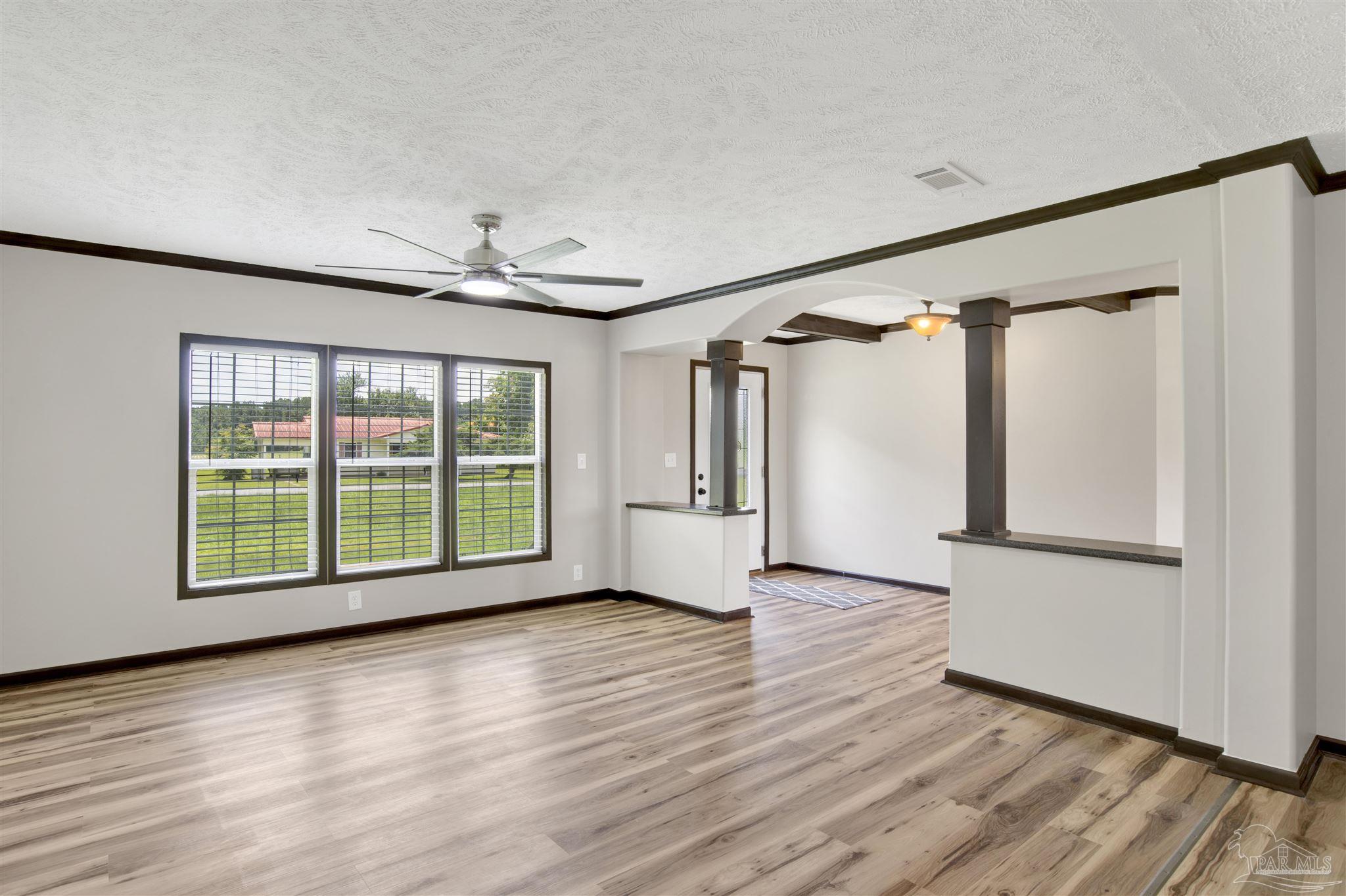 6594 Will Jones Road Jay, FL 32565 - Photo 6 of 39 a view of an empty room with wooden floor and a window