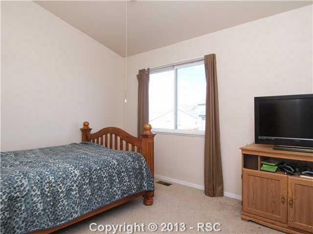 8072 Ferguson Road Peyton, CO 80831 - Photo 13 of 21 Bedroom 2 features vaulted ceilings and a ceiling fan