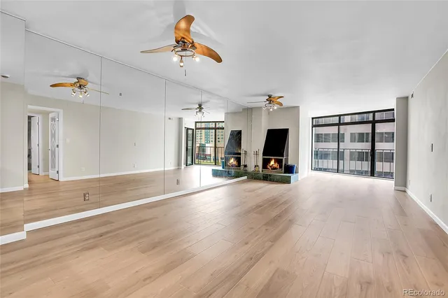 a view of a livingroom with wooden floor and a fireplace