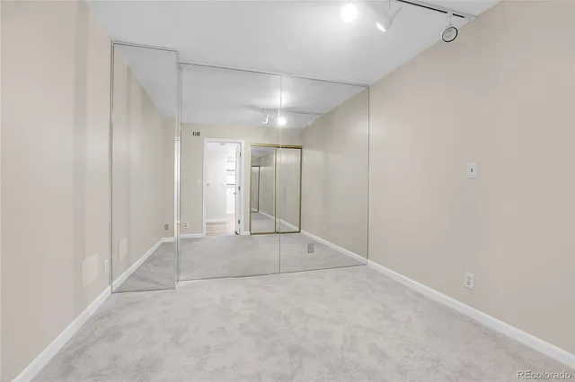 an empty room with a cabinet and mirrors