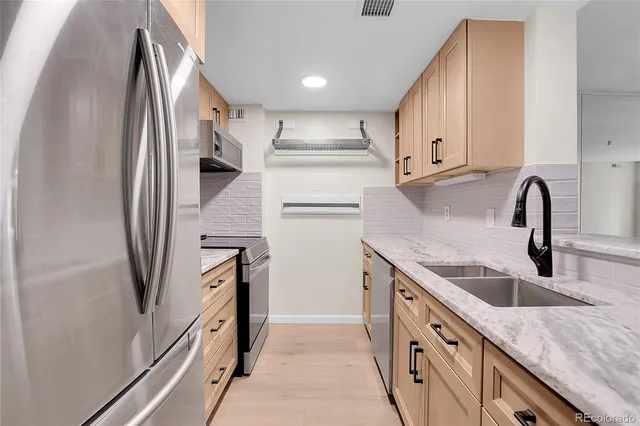 a kitchen with stainless steel appliances granite countertop a refrigerator and a sink
