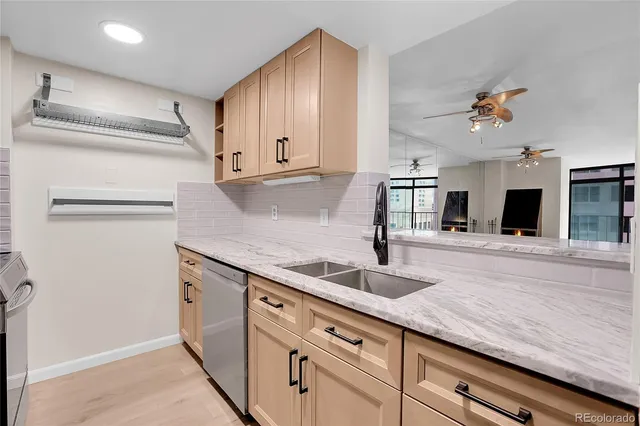 a kitchen with granite countertop a sink a counter space and cabinets