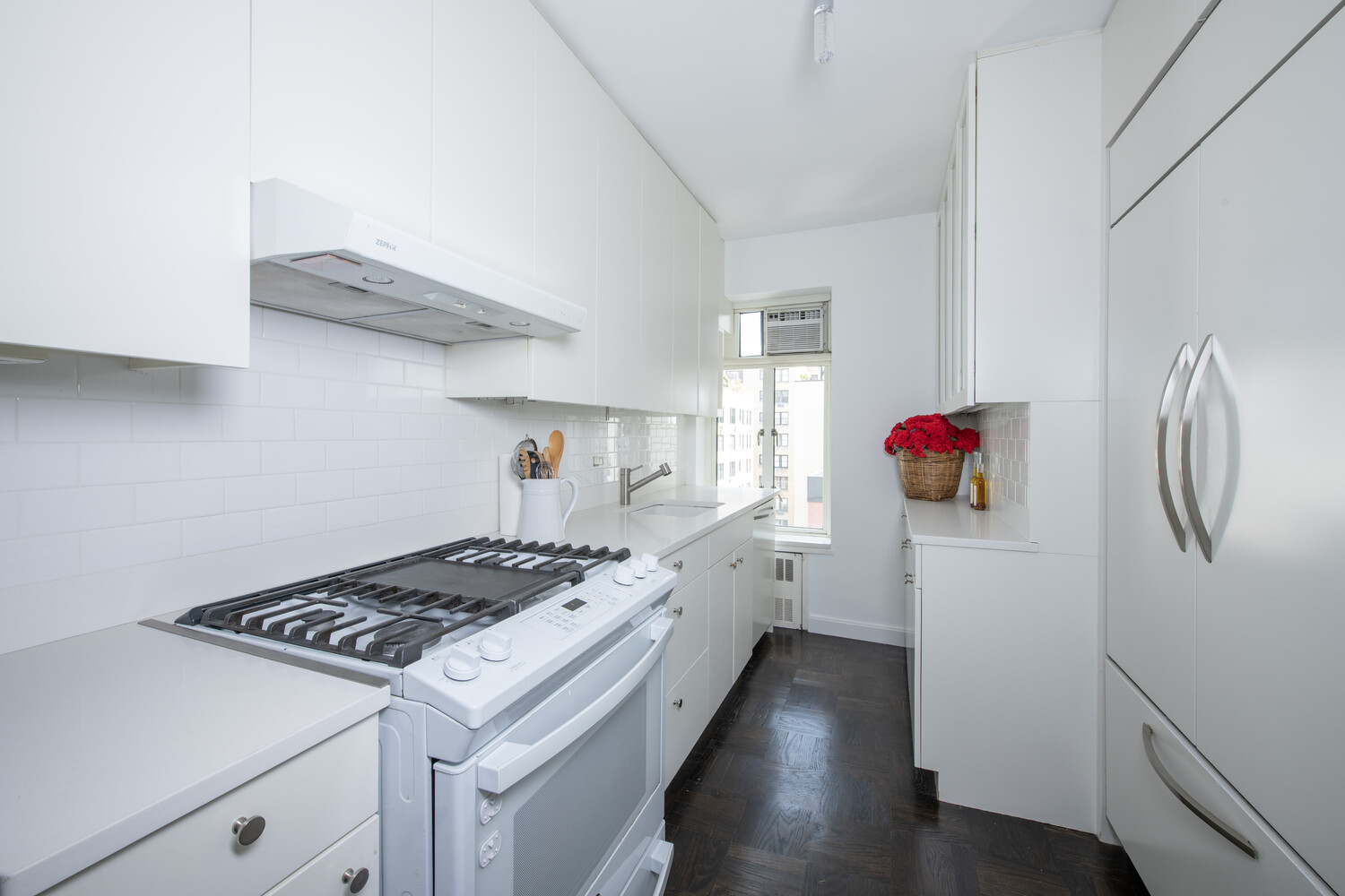 799 Park Avenue, Unit 9A Manhattan, NY 10021 - Photo 7 of 14 a kitchen with a stove and white cabinets