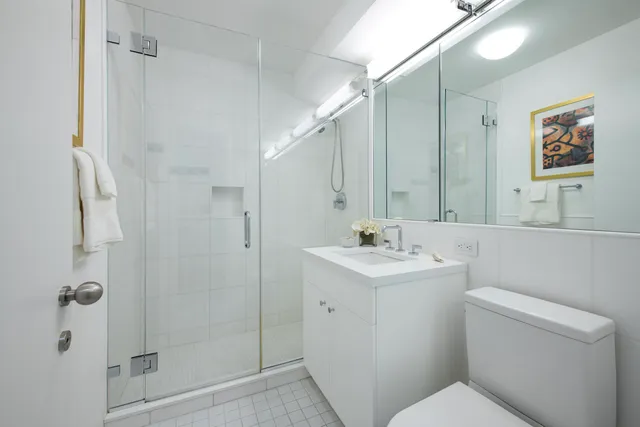 a bedroom with a bed lamp and a large window