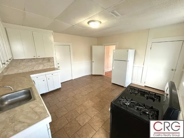 a kitchen with granite countertop a stove and a refrigerator