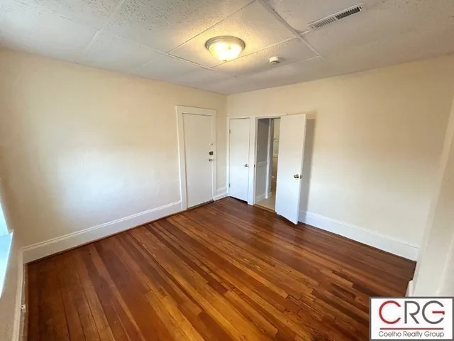 a view of an empty room with wooden floor
