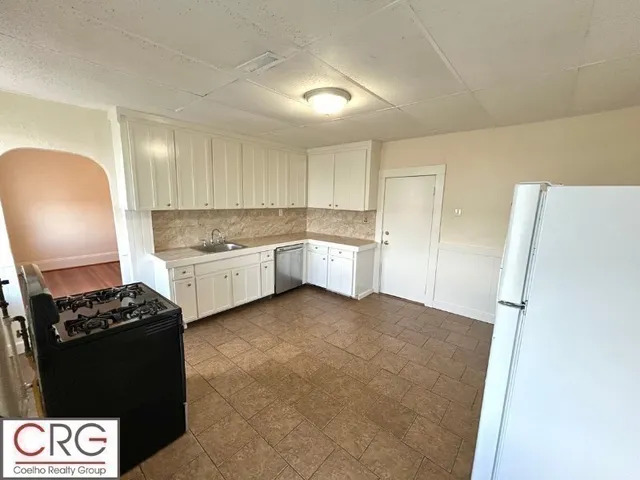 a kitchen with a stove a refrigerator and a cabinets