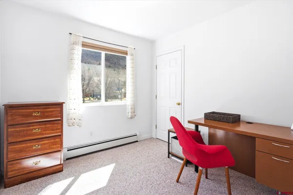 a hallway with a chair and a dresser