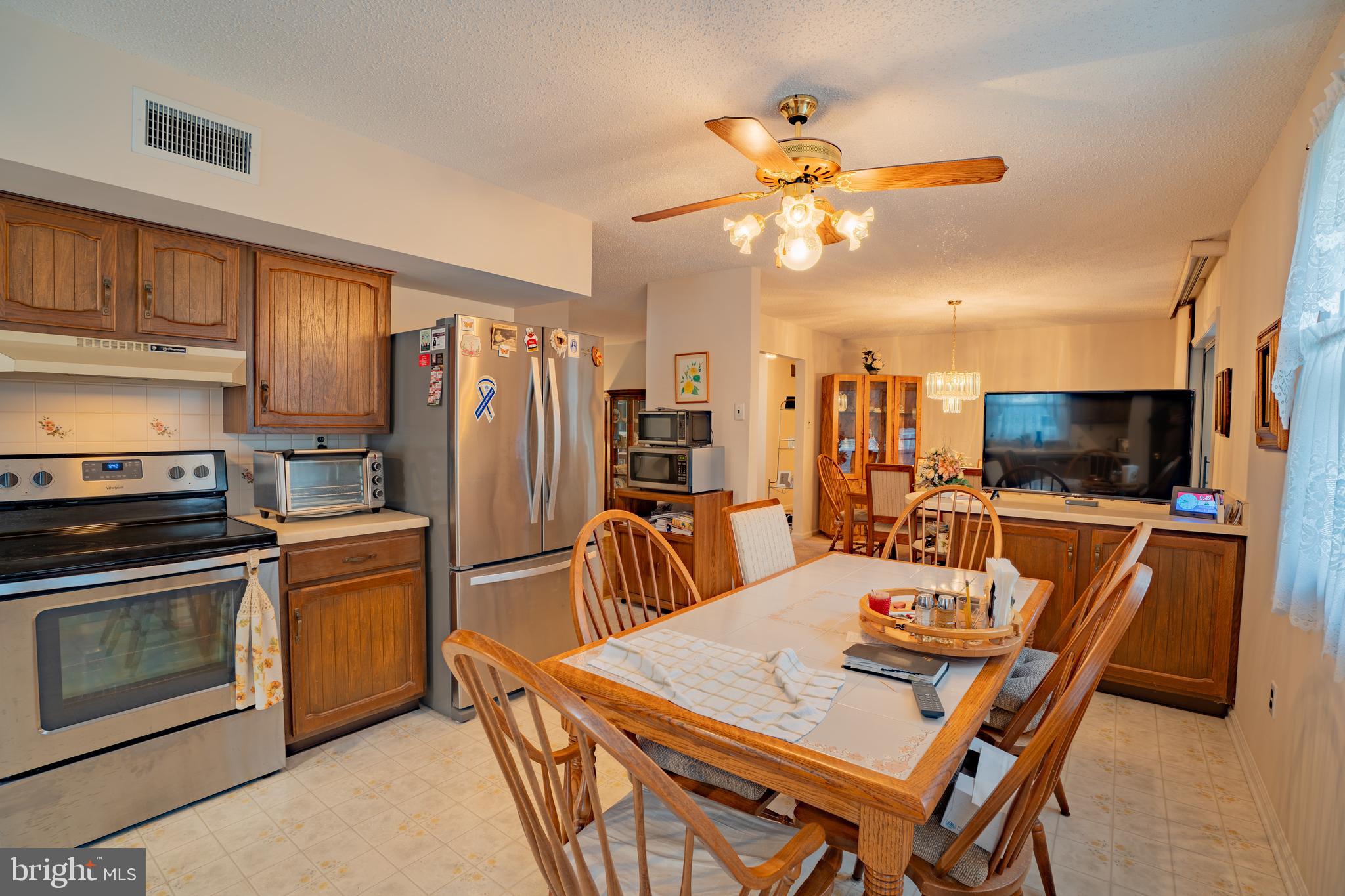 1776 1st Street Langhorne, PA 19047 - Photo 8 of 23 a kitchen with stainless steel appliances kitchen island granite countertop a refrigerator a stove a microwave oven a sink with island and chairs
