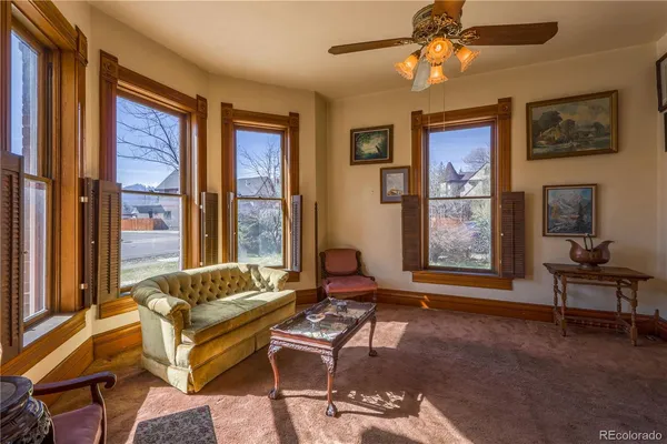 a living room with furniture and floor to ceiling windows