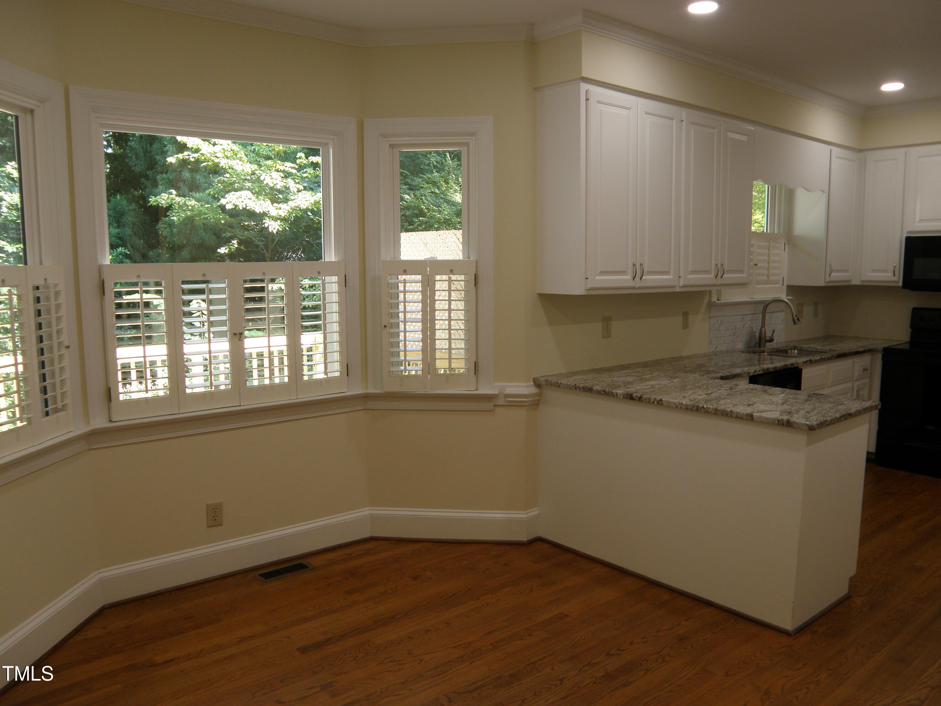 2532 Ashley Court Raleigh, NC 27607 - Photo 19 of 39 a kitchen with a sink wooden cabinets and a large window