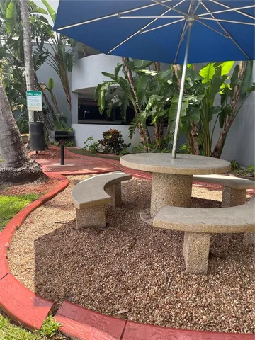 a view of a backyard with table and chairs under an umbrella