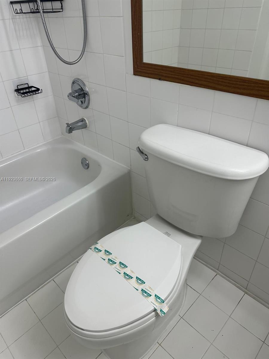 5099 Northwest 7th Street, Unit 1005 Miami, FL 33126 - Photo 29 of 35 a bathroom with a toilet and a bathtub