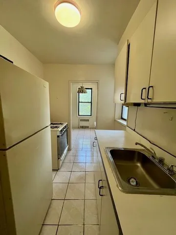 a kitchen with a sink a refrigerator and cabinets