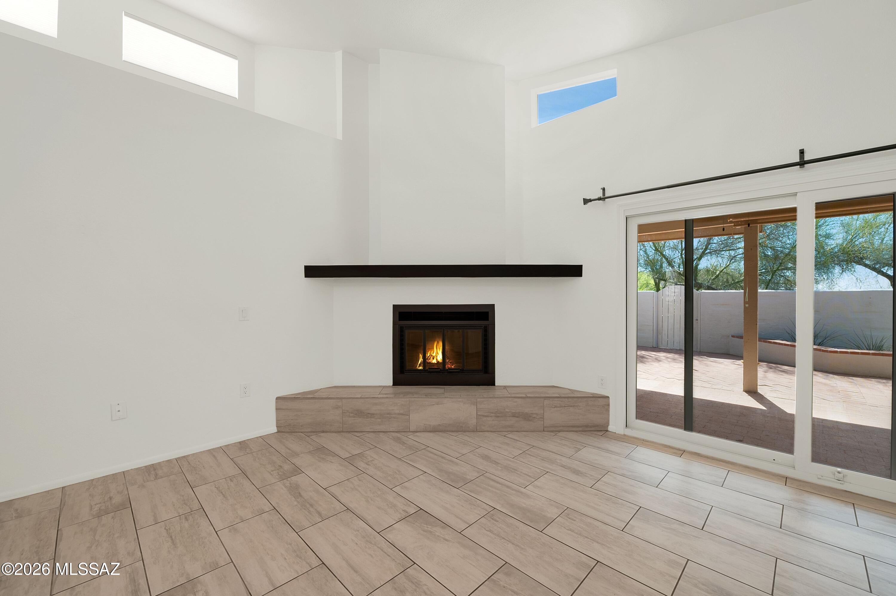 7408 East Wandering Road Tucson, AZ 85750 - Photo 7 of 25 a view of an empty room with a fireplace and a window