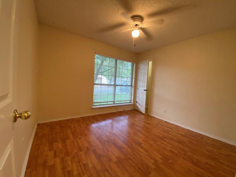 1903 Balsam Way Round Rock, TX 78665 - Photo 12 of 21 Well-lit Bed room 1 featuring rich hardwood flooring and a functional ceiling fan for optimal comfort.