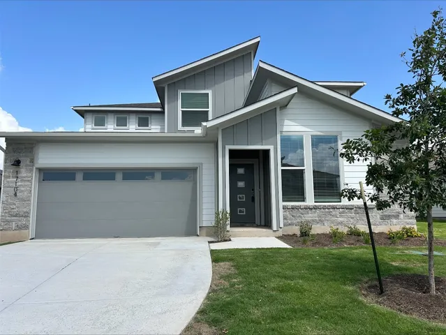 a front view of a house with a yard and garage