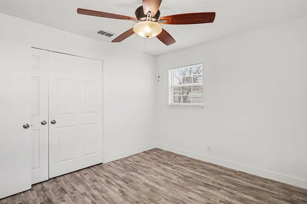 an empty room with fan and windows