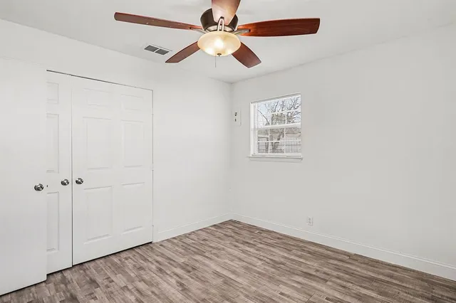 an empty room with fan and windows