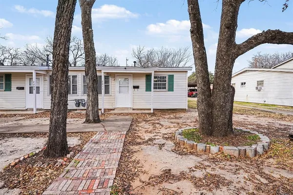a view of a house with a tree in the yard