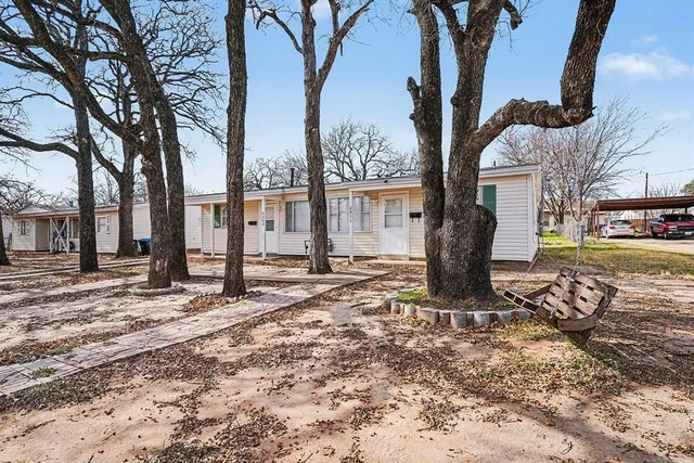 a tree in front of a white house