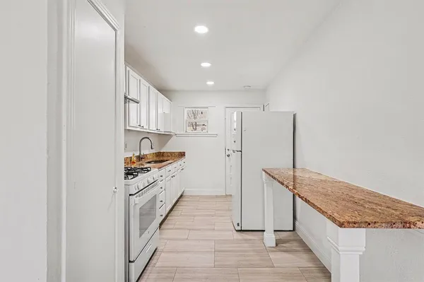 a kitchen with stainless steel appliances granite countertop a stove and a refrigerator