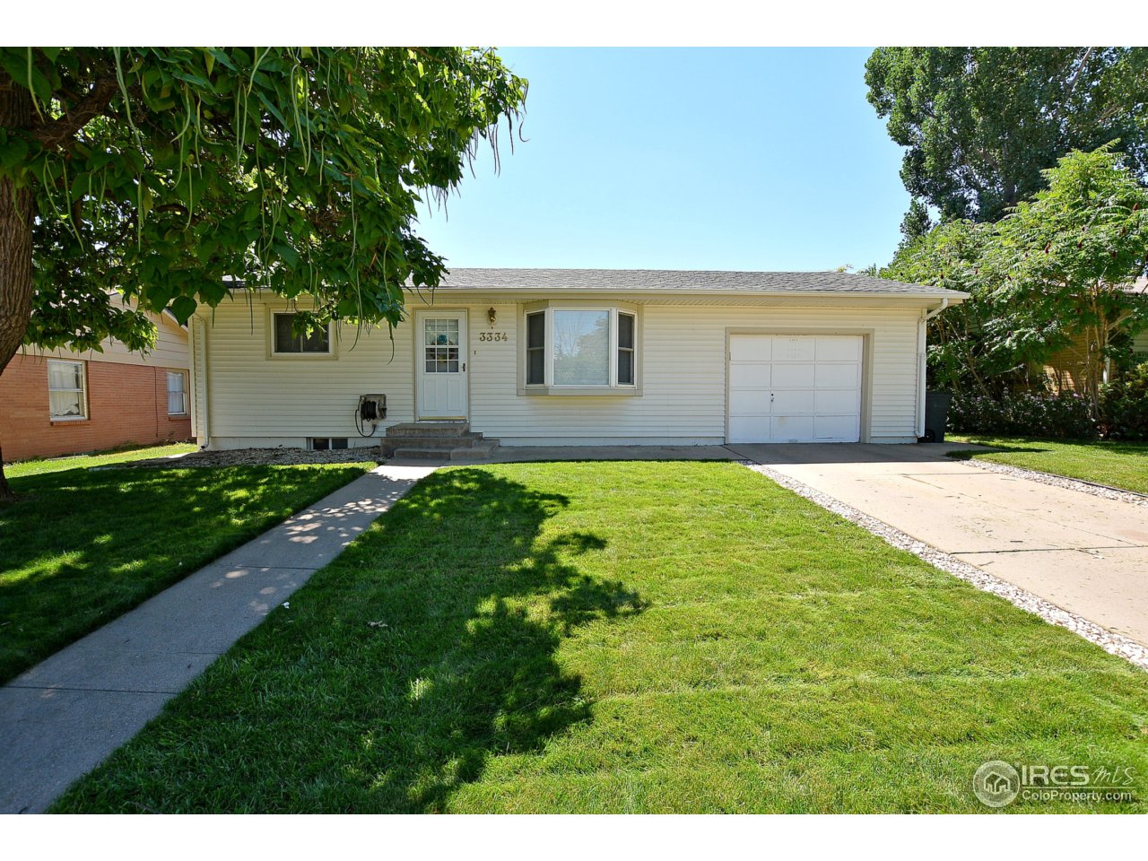 3334 West 4th Street Road Greeley, CO 80634 - Photo 1 of 34 a front view of a house with a yard and garage