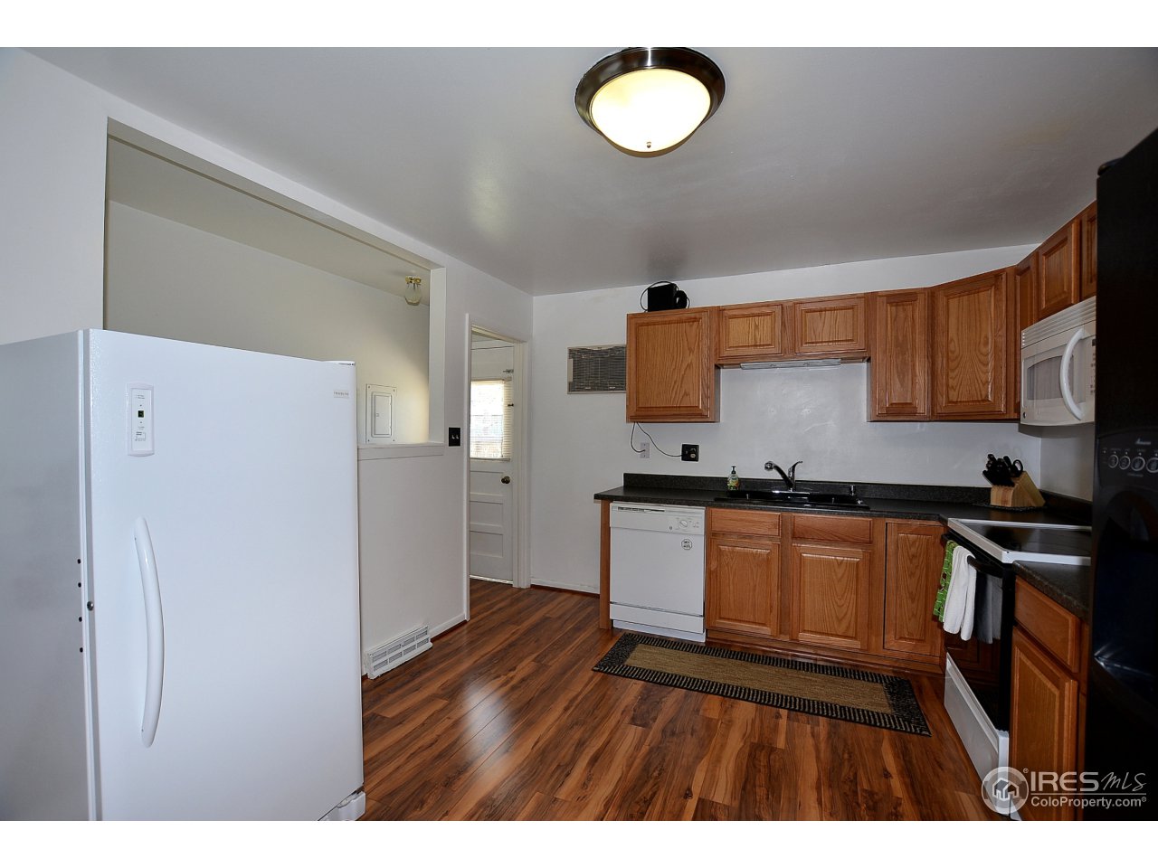 3334 West 4th Street Road Greeley, CO 80634 - Photo 8 of 34 a kitchen with granite countertop a refrigerator stove top oven and sink