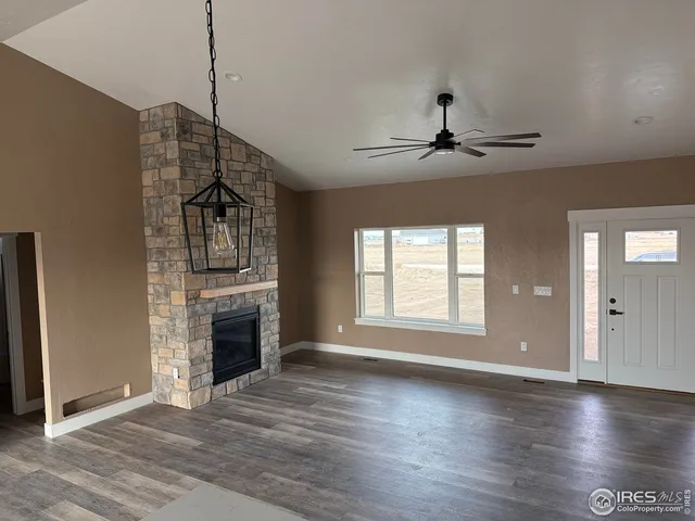 a view of an empty room with a fireplace and a window