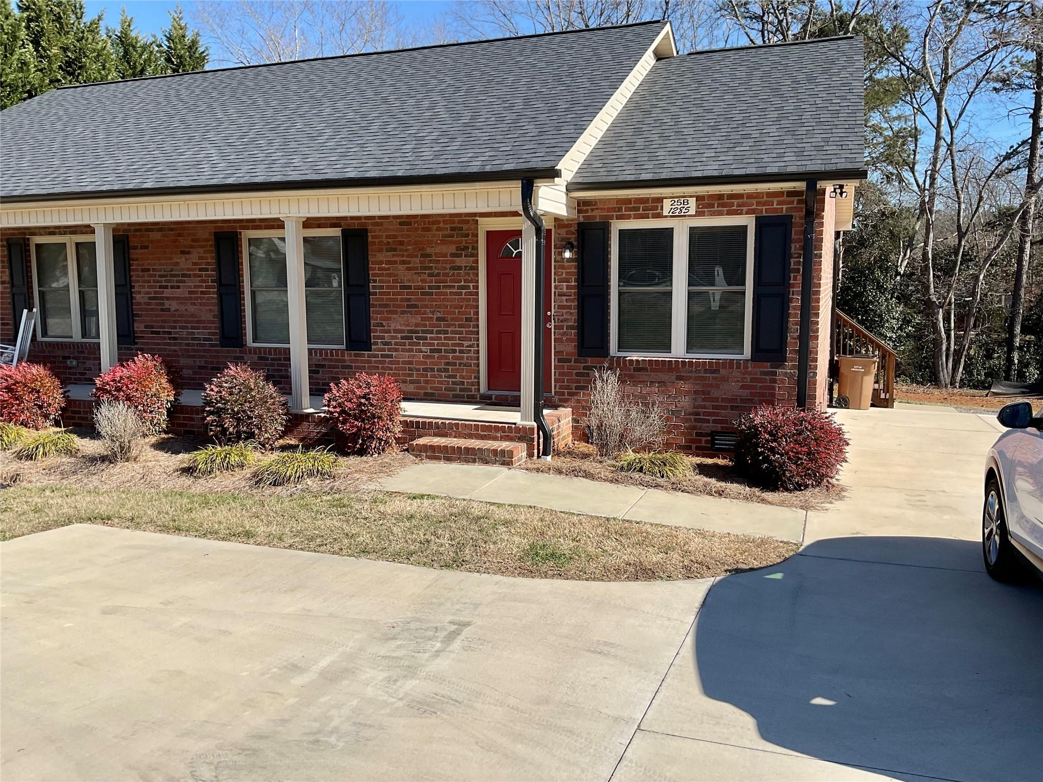 a front view of a house with a yard and seating space