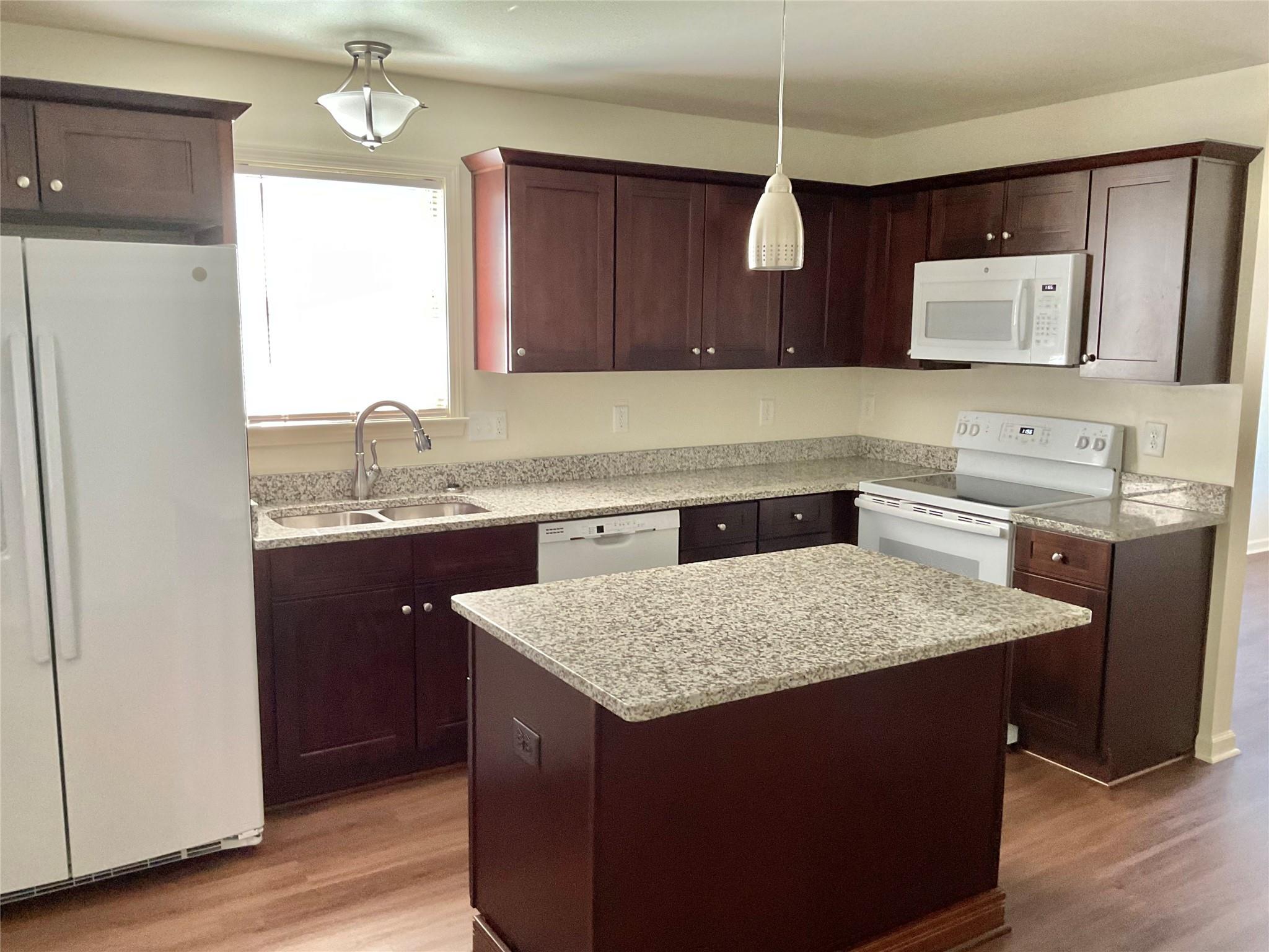 1285 Janice Road Lincolnton, NC 28092 - Photo 4 of 19 a kitchen with a stove a sink a refrigerator and wooden cabinets