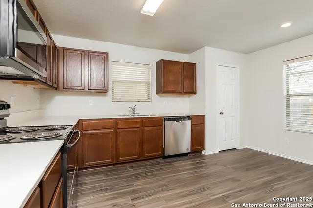 a kitchen with granite countertop a stove top oven sink and cabinets