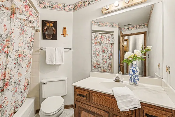 a bathroom with a granite countertop sink a toilet and a shower curtain