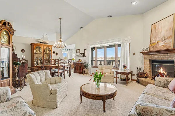a living room with furniture a fireplace and a chandelier
