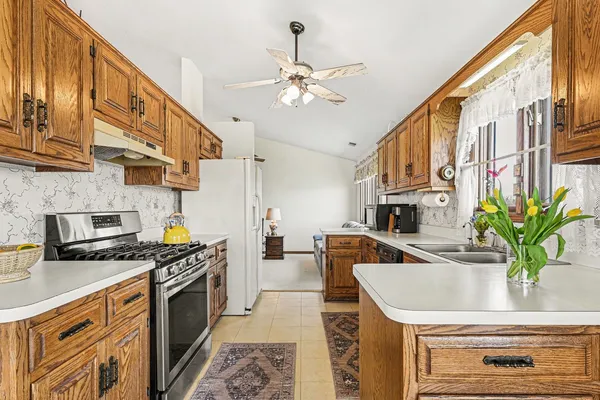 a kitchen with stainless steel appliances granite countertop a sink a stove and cabinets
