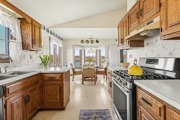 a kitchen with stainless steel appliances granite countertop a stove a sink and a microwave