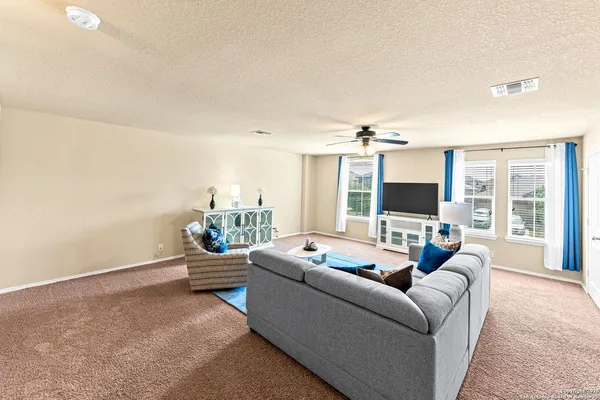 a room with chandelier fan and a table