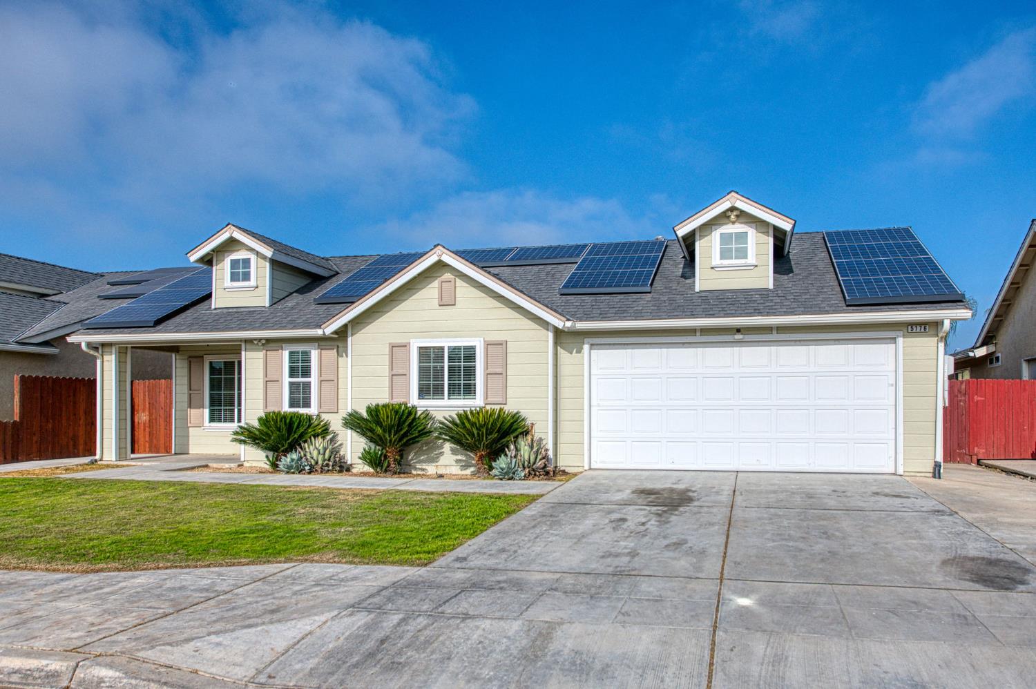 5176 West Michigan Avenue Fresno, CA 93722 - Photo 20 of 37 a front view of a house with a yard and garage