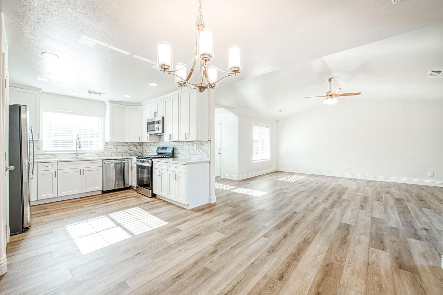 5176 West Michigan Avenue Fresno, CA 93722 - Photo 27 of 37 a large kitchen with granite countertop a large center island a sink stainless steel appliances and cabinets